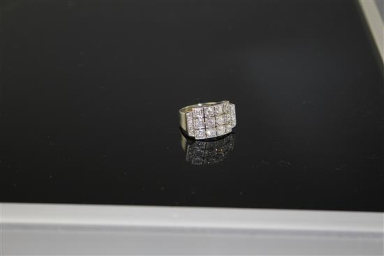 A white metal (stamped 750 and Pt 950) and pave diamond set cocktail ring, of curved design and set with twenty round cut stones.